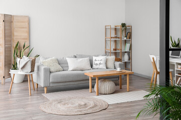 Modern table and sofa in interior of light room