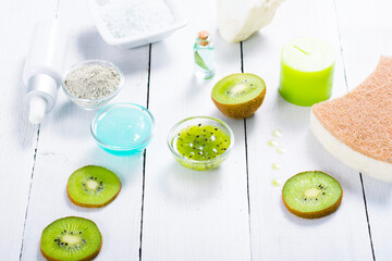 beauty products with kiwi fruit ingredient on white wooden table