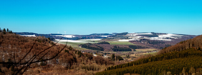 Panoramo von verschneiten Bergen vor Blauem Himmel