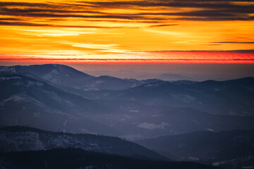 Obraz na płótnie Canvas Winter sunset seen from Pilsko in Beskid Żywiecki. Beautiful views of the Tatras and the Mala Fatra massif, bathed in golden light.