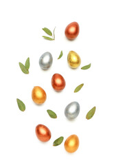Stylish painted Easter eggs and green leaves on white background