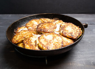 Baked in pan fritters with sour cream on black background