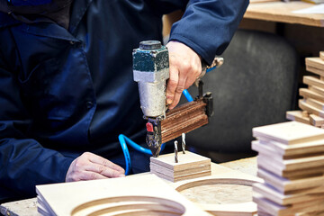 Worker with nailing gun in a workshop