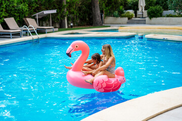 Woman and girl swimming in pool