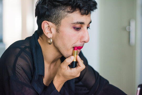 Non binary person applying drag make up