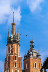 Between the two towers of the old castle in the blue sky two doves fly on a sunny day