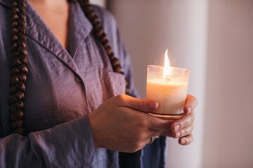 Anonymous woman holding burning candle