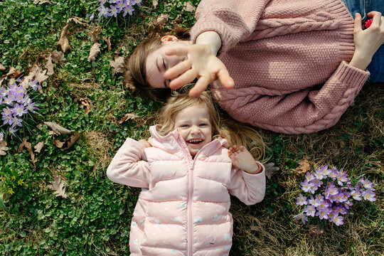 Mother and child playing while lying on lawn