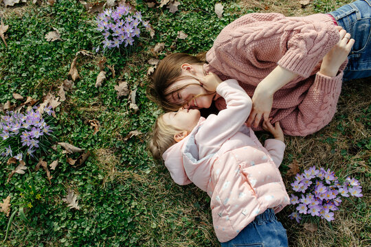 Mother and daughter hugging lying on lawn