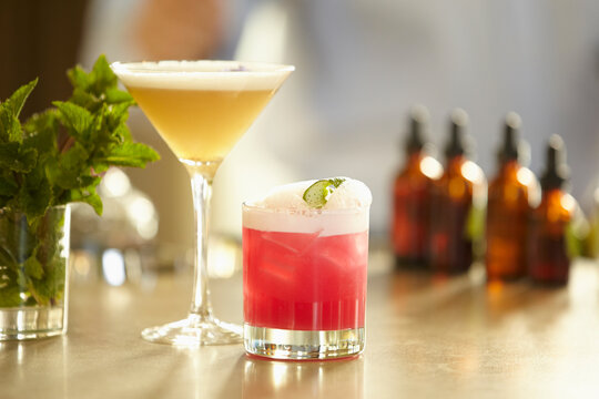 Artisan cocktails on a bar with tinctures and mint