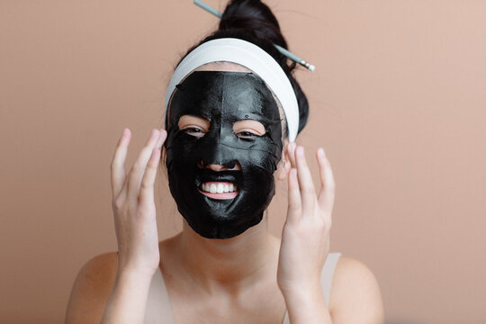 Laughing Girl Applying One Piece Purifying Facial Mask 