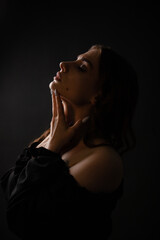 Obraz premium Sexy silhouette of a beautiful girl on a dark plain background. Portrait.