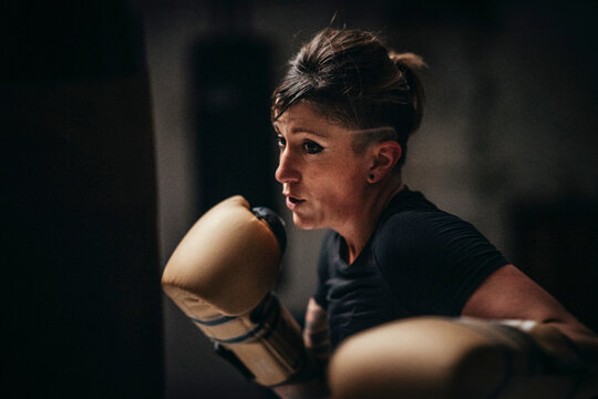 Focused strong woman boxing in gloves