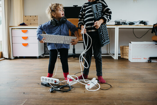 Two lovely kids playing with electronic equipment