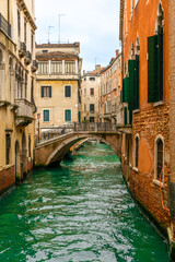 December 2, 2021 - Venice, Italy: An arched bridge across the narrow canal.