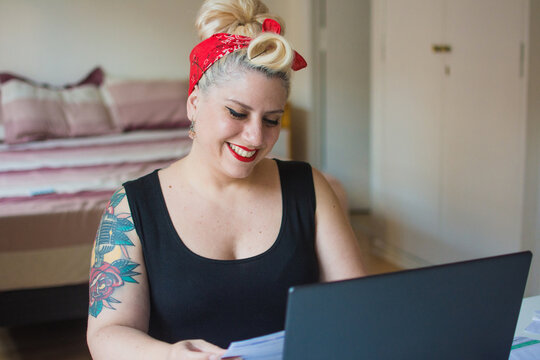 Happy woman with tattoos working from home