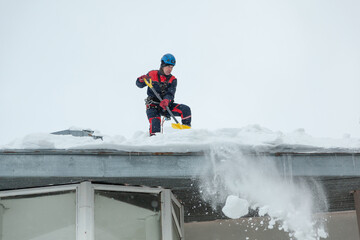 Climber clears snow from roof