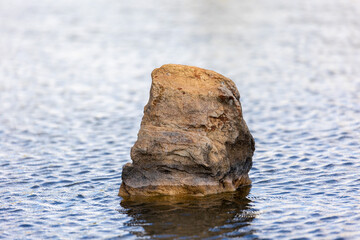 A rock in the middle of the lake.
