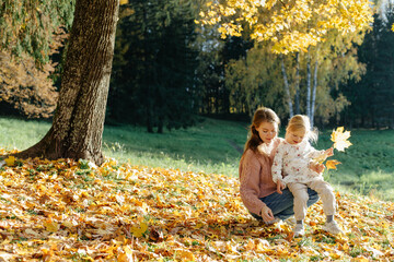 Woman and child collecting leaves in park