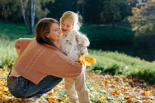 Mother and child hugging in autumn park