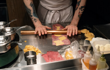 Crop chef rolling different dough for pasta