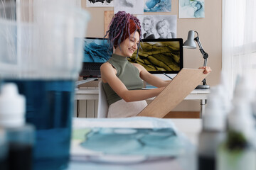 Cheerful female artist drawing at home