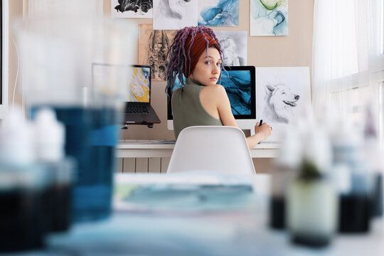 Female artist looking at camera over shoulder