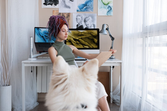Serious female artist sketching dog