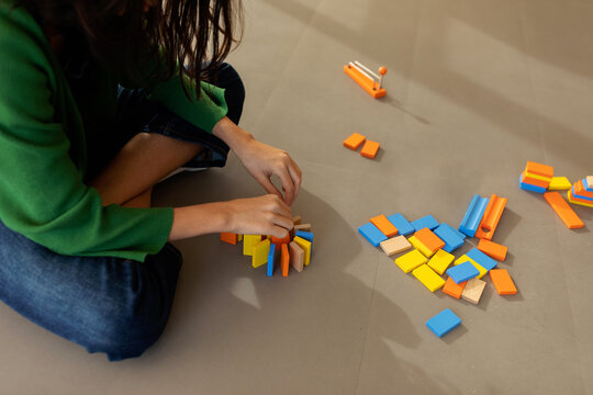 Girl doing circuit with dominoes on a playdate