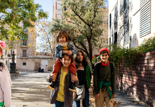 Siblings walking by the city after school in fall