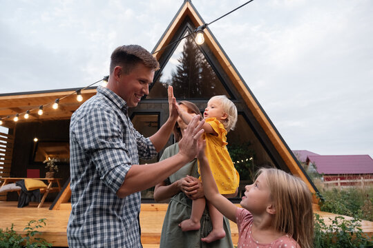 Happy father giving high fives to daughters