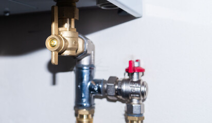 Fototapeta na wymiar Pipes and taps of heating boiler close-up