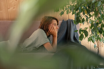 Dreamy female relaxing on couch