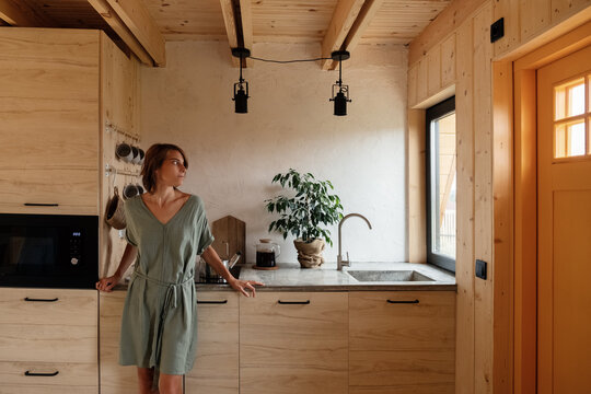 Woman resting in kitchen of countryside house