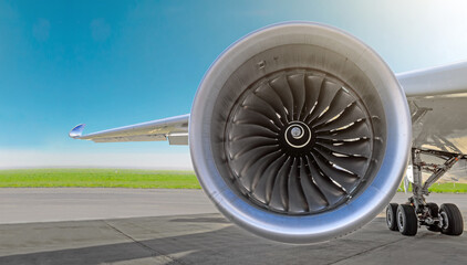 Aircraft jet engine close-up, airplane wing and chassis of landing gear wheel parked at the airport...