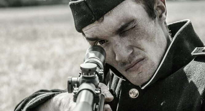 a soldier takes aim at a rifle, pulls the bolt