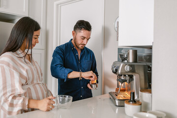 Young couple making coffee in kitchen