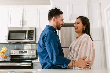 Expectant couple in love at kitchen