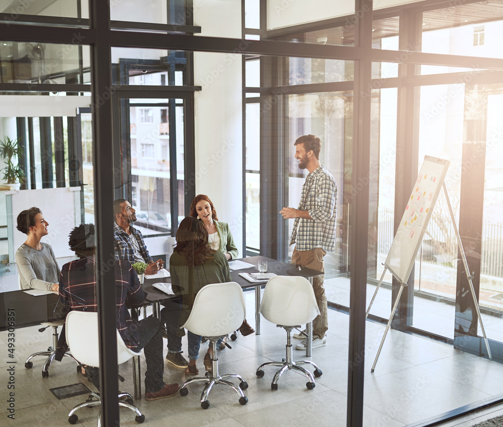 Poster generating new ideas together. shot of a businessman giving a presentation to his coworkers in a mod