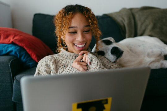 Happy smiling girl looking at computer at home 