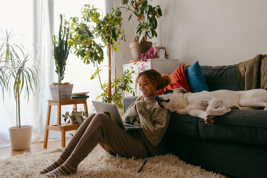Young girl at home streaming while bonding with dog