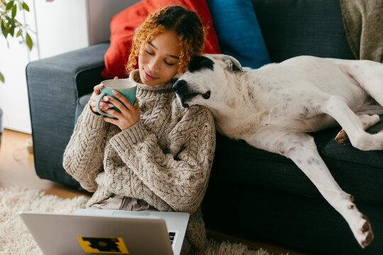 cozy scene of girl drinking tea bonding with her dog 