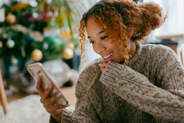 Girl smiling looking at her smartphone in Christmas