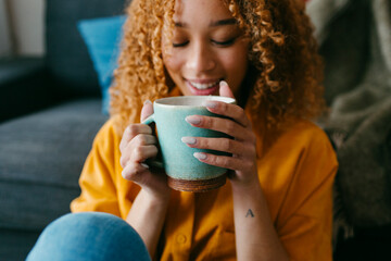 Young woman's hands holding a green cup