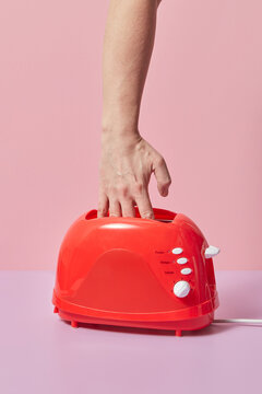 Woman holding hand in toaster