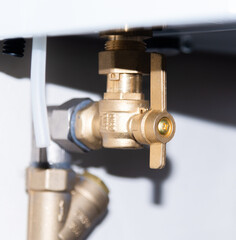 Pipes and taps of heating boiler close-up