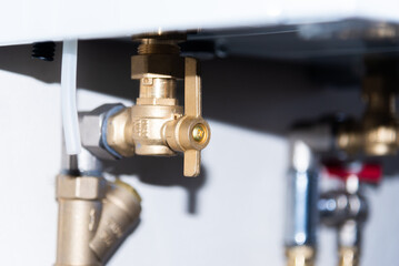 Pipes and taps of heating boiler close-up