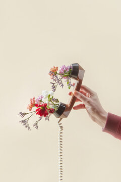Fototapeta Man holding phone handset with spring flowers
