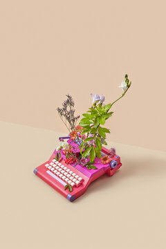 Vintage typewriter spitting out colorful spring flowers