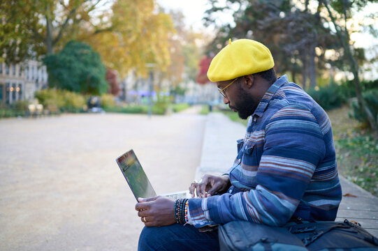 black manworking on  computer in a park